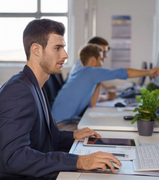 Young,Businessman,Synchronising,Data,Between,His,Tablet,Pc,And,Desktop Young,Businessman,Synchronising,Data,Between,His,Tablet,Pc,And,Desktop